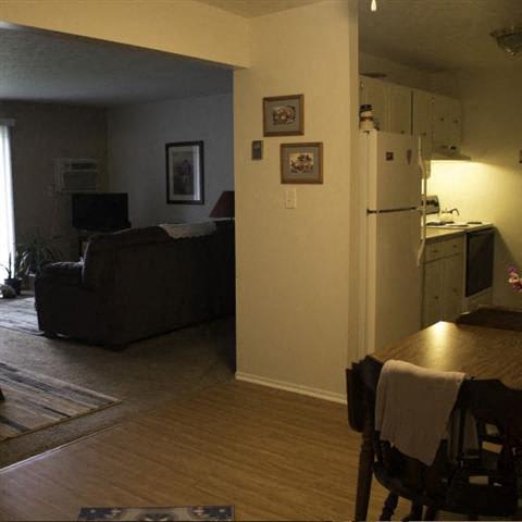 a living room with a couch a table and a refrigerator