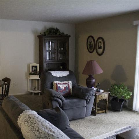 a living room filled with furniture and a lamp