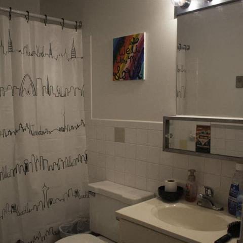 a bathroom with a white toilet and a white sink