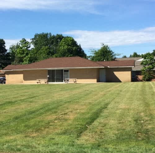 a brick building where the party center is located with a large grass lawn in front of it