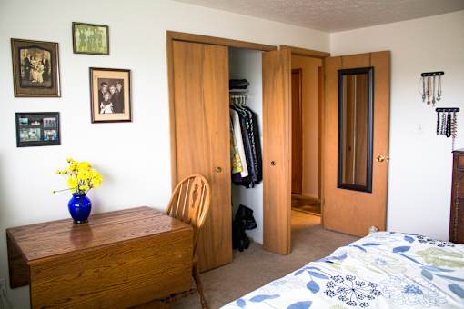 a bedroom with a bed and a table and a closet
