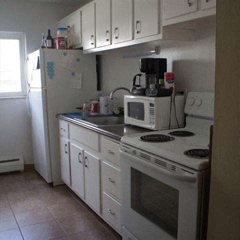a kitchen with a stove, microwave, and refrigerator