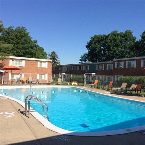 a large swimming pool in front of brick apartment buildings