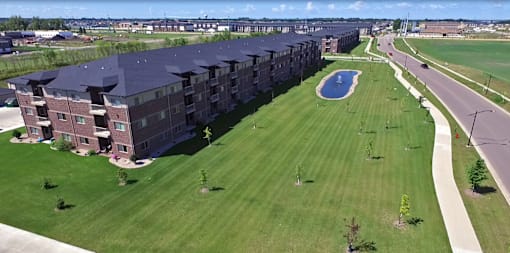 exterior, large building, grass, pond, fargo apartment