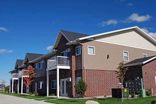 exterior of moorhead apartment, blue sky, green grass