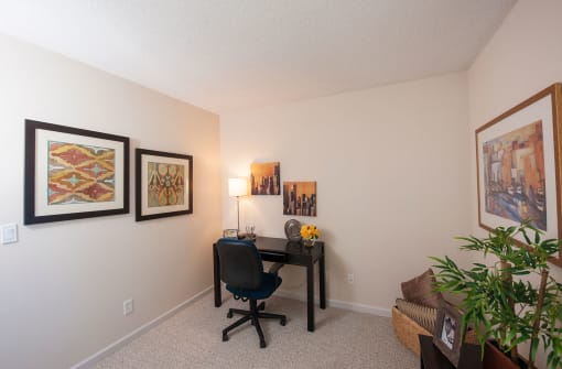 a home office with a desk and pictures on the wall