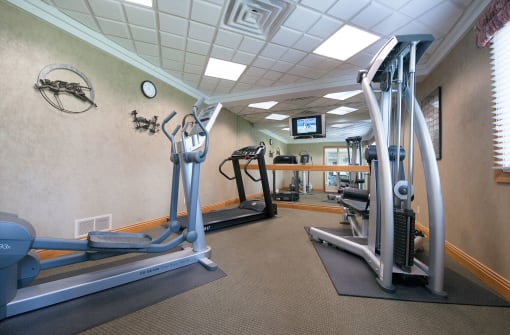 a gym with exercise equipment and a tv on the wall
