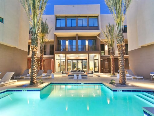 Scottsdale, AZ, Apartments For Rent - 24-Hour Resort-Inspired Pool With Lounge Chairs, Tables, And Resident Lounge Buliding In The Background.