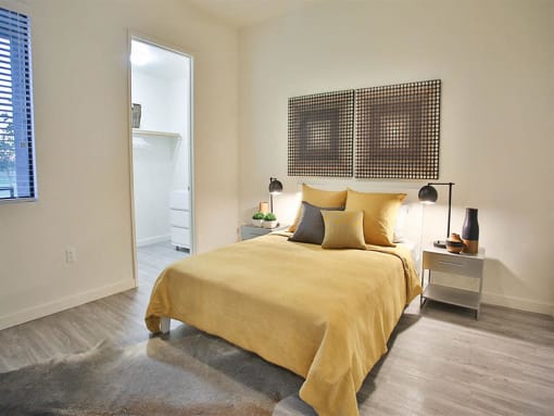 One and Two BR Apartments in Scottsdale AZ - Dusk Scottsdale - Bedroom with Wood-Style Flooring, Area Rug, Bed, Nightstands, Lamps, and Walk-In Closet
