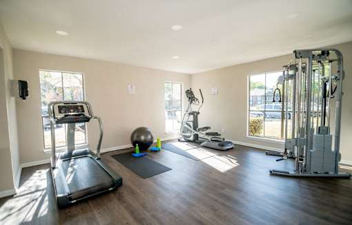 Fitness center with treadmill and other gym equipment.