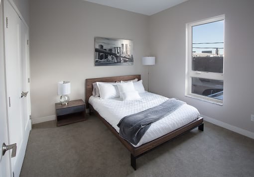 A bedroom with a bed and two nightstands at RoCo Apartments, Fargo, North Dakota 58102