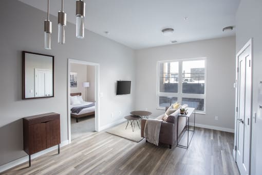A living room with gray walls and hardwood floors at RoCo Apartments, Fargo, North Dakota 58102