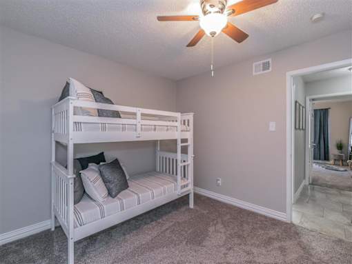 Bedroom with large window and ceiling fan in Riata Park Apartment