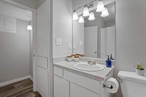 bathroom with large mirror, vanity lighting, and updated fixtures