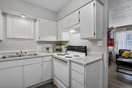 White kitchen with refrigerator, oven, and ample cabinets