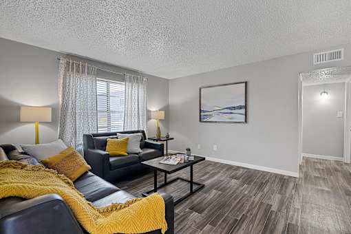 Living room with accent chair, sofa, and bright windows