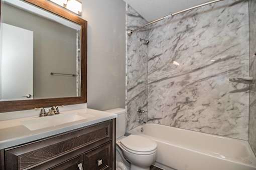 Bathroom with modern vanity and bright mirror lighting at Verano Oaks