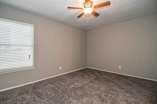Bedroom with ceiling fan and plush carpet flooring at Verano Oaks Apartments