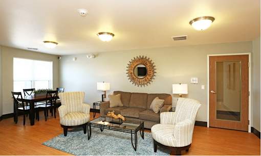 Community room with a couch, chairs, and a coffee table.