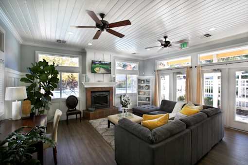 Open living room with gray sectional and fireplace at Liberty Hill Apartments, Utah