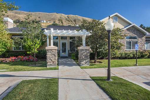 Residential community entrance with stone columns and walkway at Liberty Hill Apartments, Draper, UT