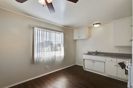 Dining area with ceiling fan, wood style floors, open kitchen on the right