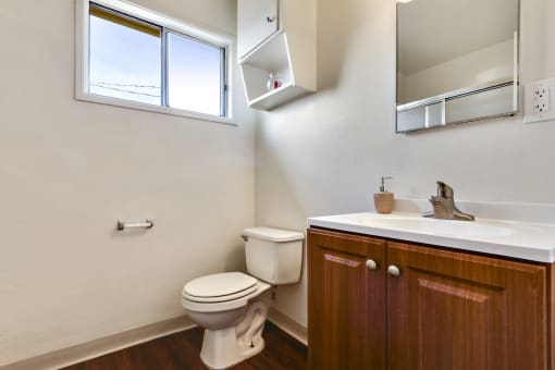 Bathroom with wood style single vanity, White single cabinet above the toilet