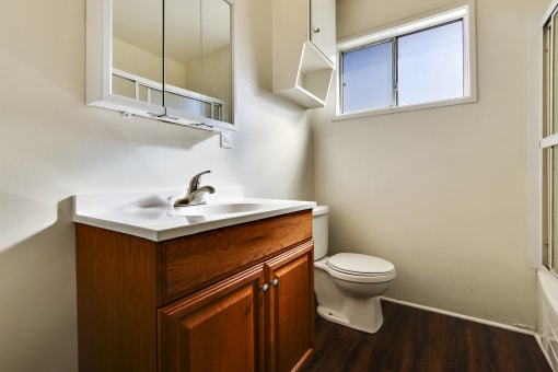 Bathroom with wood style single vanity cabinet, hardwood style flooring