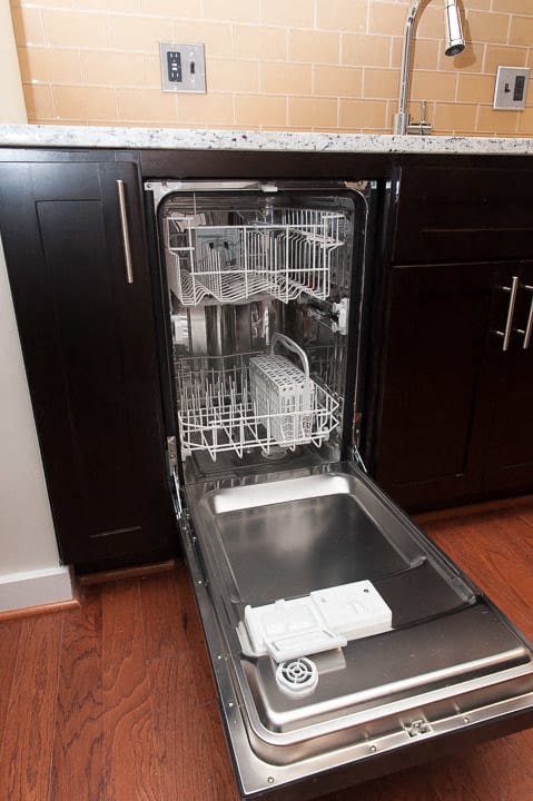 a dishwasher with its door open in a kitchen