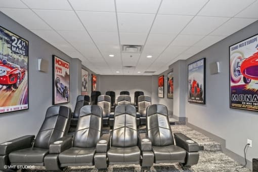 a theater room with leather chairs and movie posters on the walls
