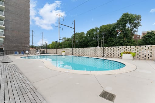 a swimming pool at an apartment building with trees in the background