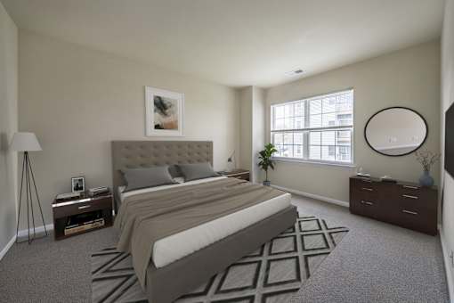 Bedroom with cozy bed and lamps at The Apartments at Owings Run, Owings Mills, MD