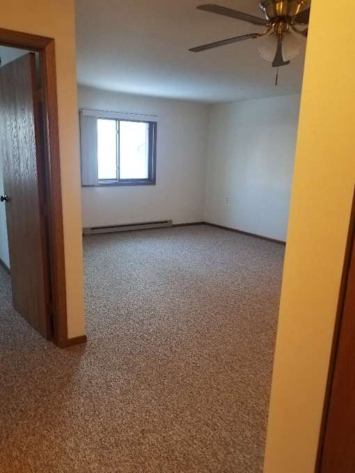 A room with a ceiling fan and a window.