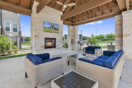 Apartments in San Marcos - Sadler House - Community Patio Equipped with a Large Fire Place, Comfy Outdoor Couches, Large Flat Screen TV, Shaded Overhang, Ceiling Fan, and Shared BBQs.
