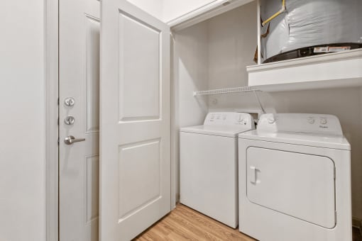 Apartments in San Marcos-Sadler House-Laundry Room- White Washer and Dryers, Wood-Style Floors, and Storage Space