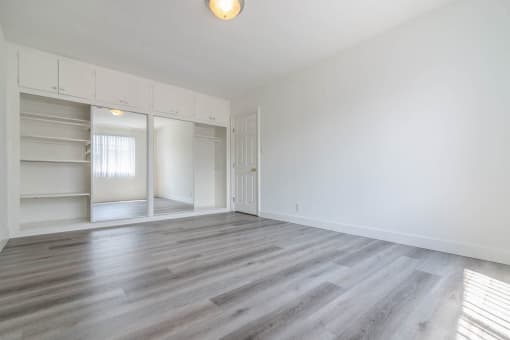Bedroom with huge glass sliding door closets with built in shelves