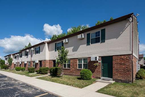 A row of houses with green doors and windows.