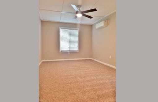 View of bedroom with well it window, ceiling fan, and AC