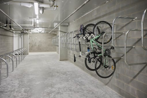 a row of bikes hanging on a wall in a parking garage