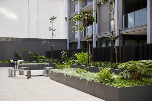 a courtyard with benches and plants in front of a building