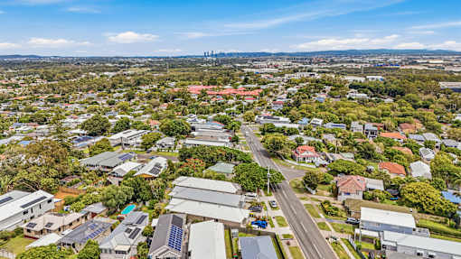 A bird's eye view of a residential area with houses and solar panels.