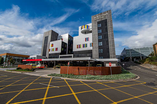 A hospital building with a red stop sign in front of it.
