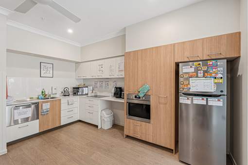 A kitchen with a refrigerator covered in magnets and notes.