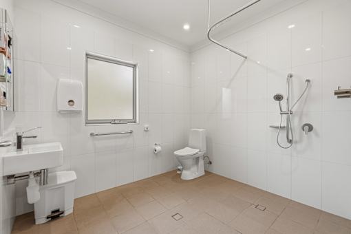 A white bathroom with a toilet, sink, and shower.