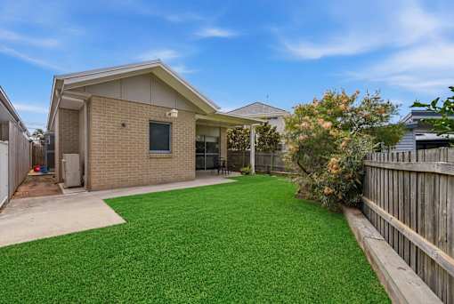 A house with a green lawn in front.