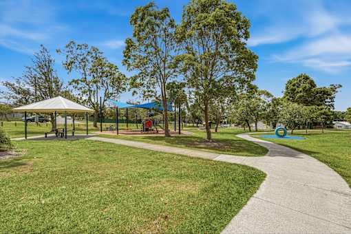 A park with a walking path, a gazebo, and a playground.