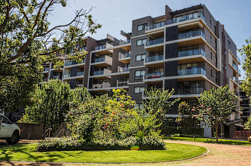 A modern apartment building with a well-maintained lawn in front.