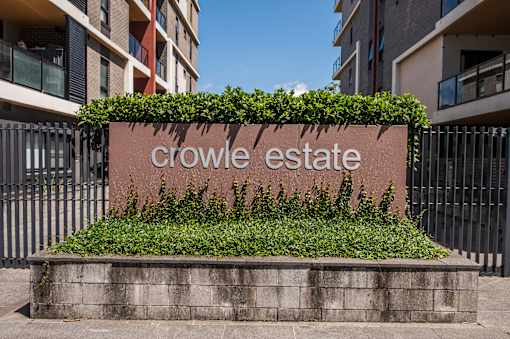A sign that says "Crowle Estate" is surrounded by greenery.