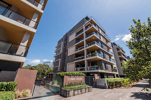 A modern apartment building named Crowle Estate with a gated entrance and greenery.