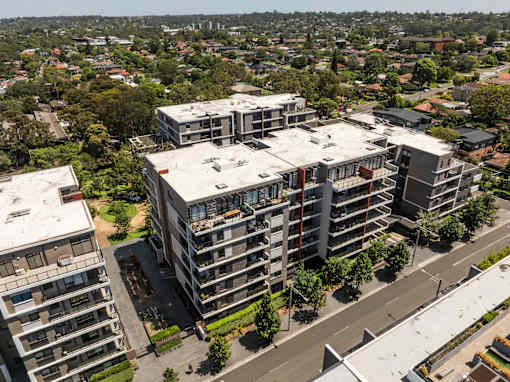 A large apartment complex sits in the middle of a city street.